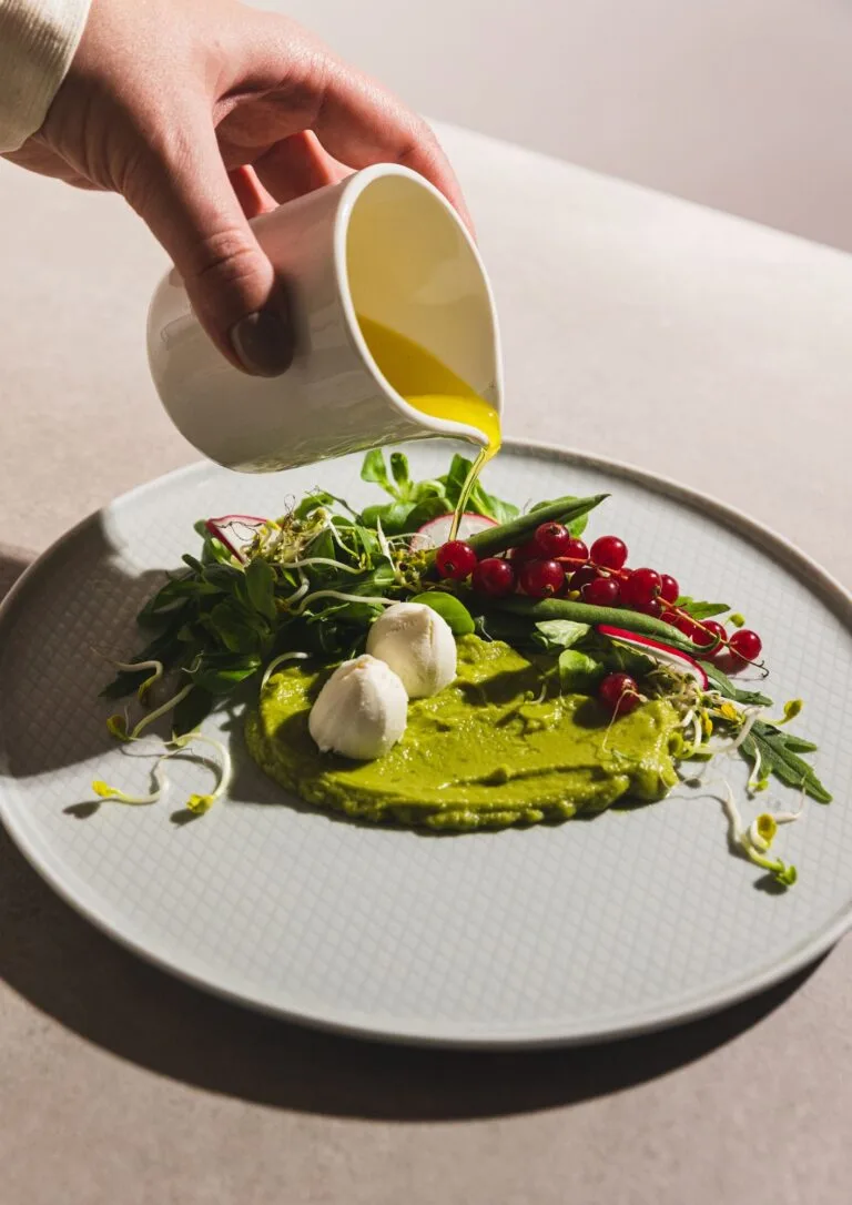 Chef vertiendo aceite sobre un plato de autor