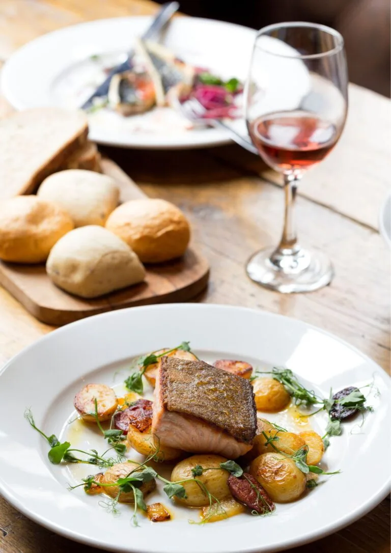 Pescado con patatas, pan y copa de vino