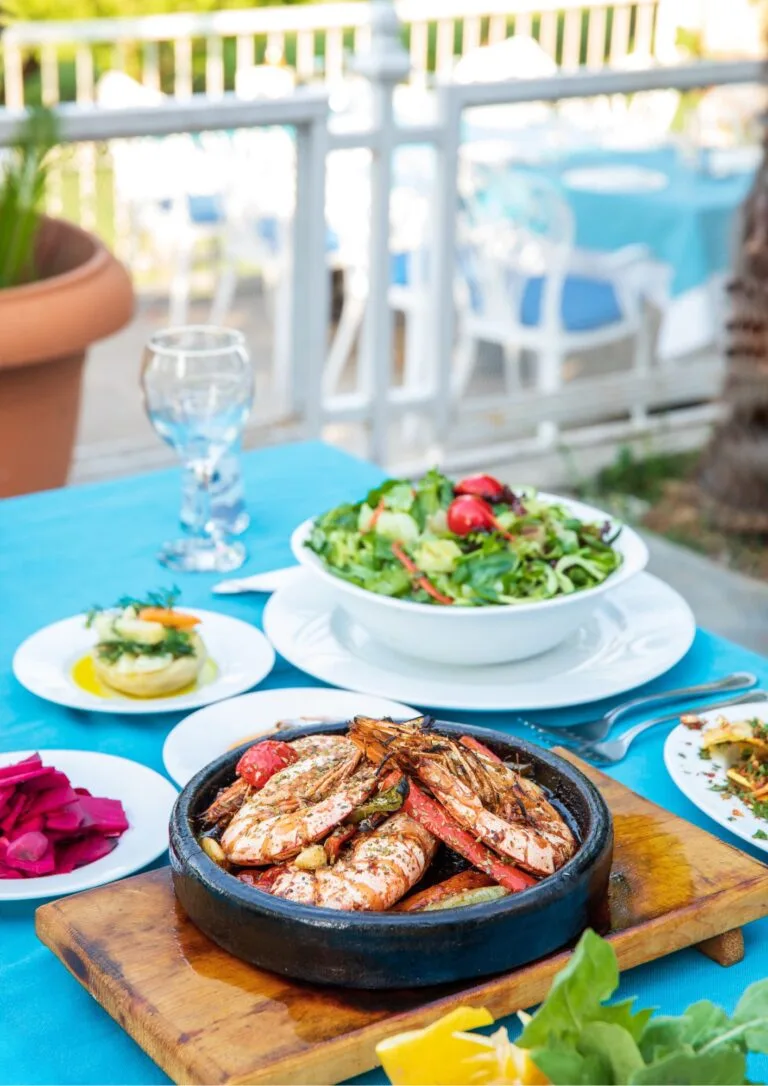 Mesa de terraza con varios platos de pescado