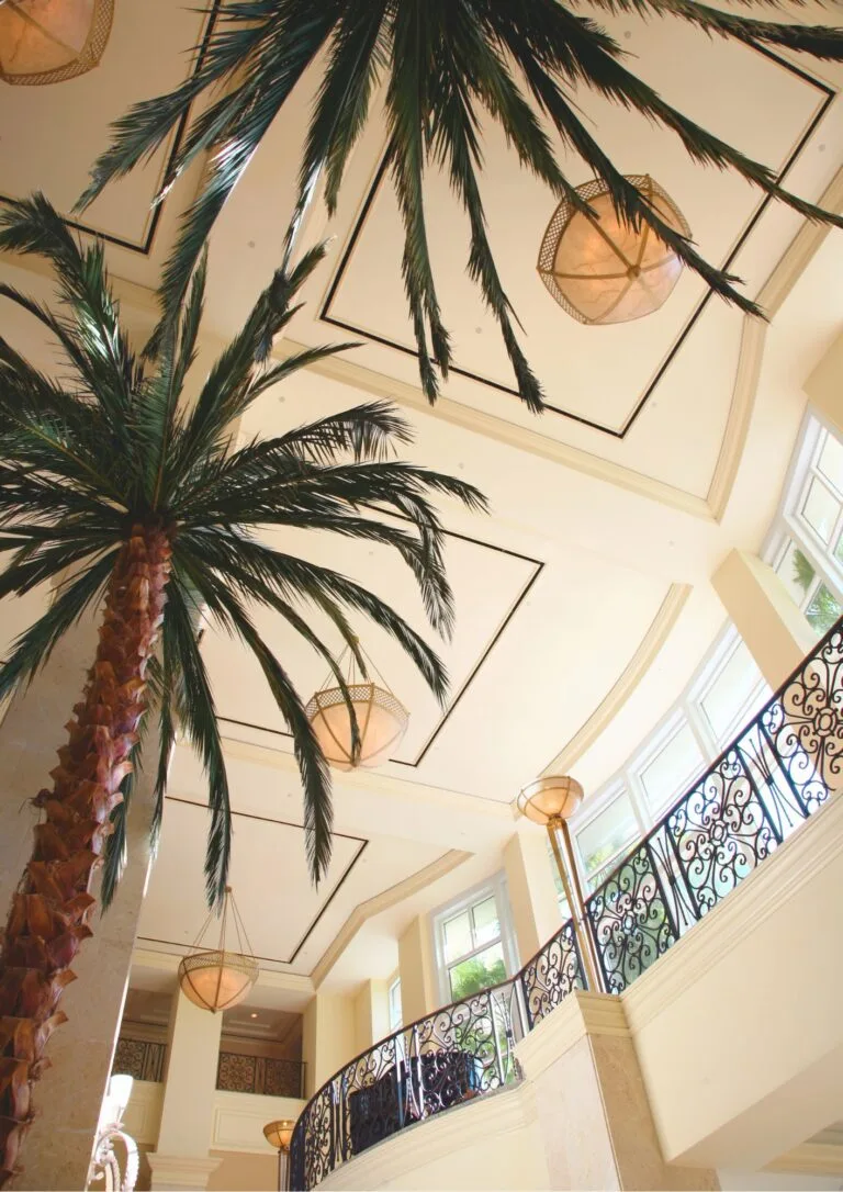 Escalera interior con lámparas de fibra y palmera