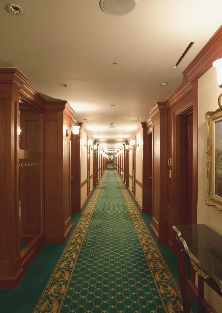 Pasillo de hotel clásico con moqueta y molduras
