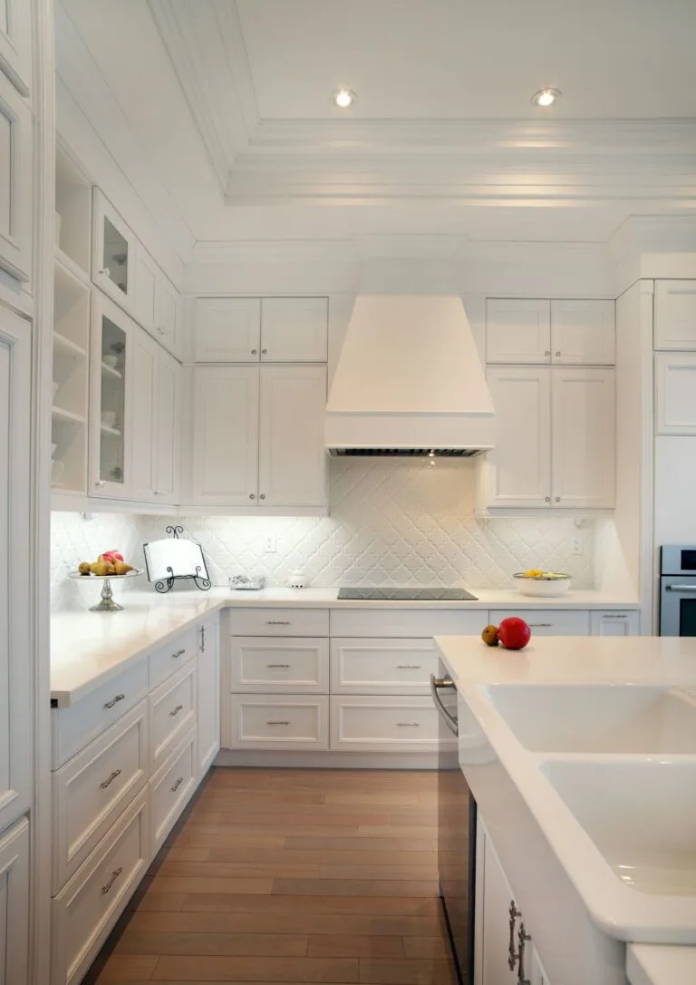 Cocina blanca con isla central y campana de obra