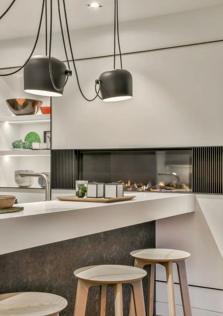 Cocina abierta con chimenea moderna y taburetes de madera