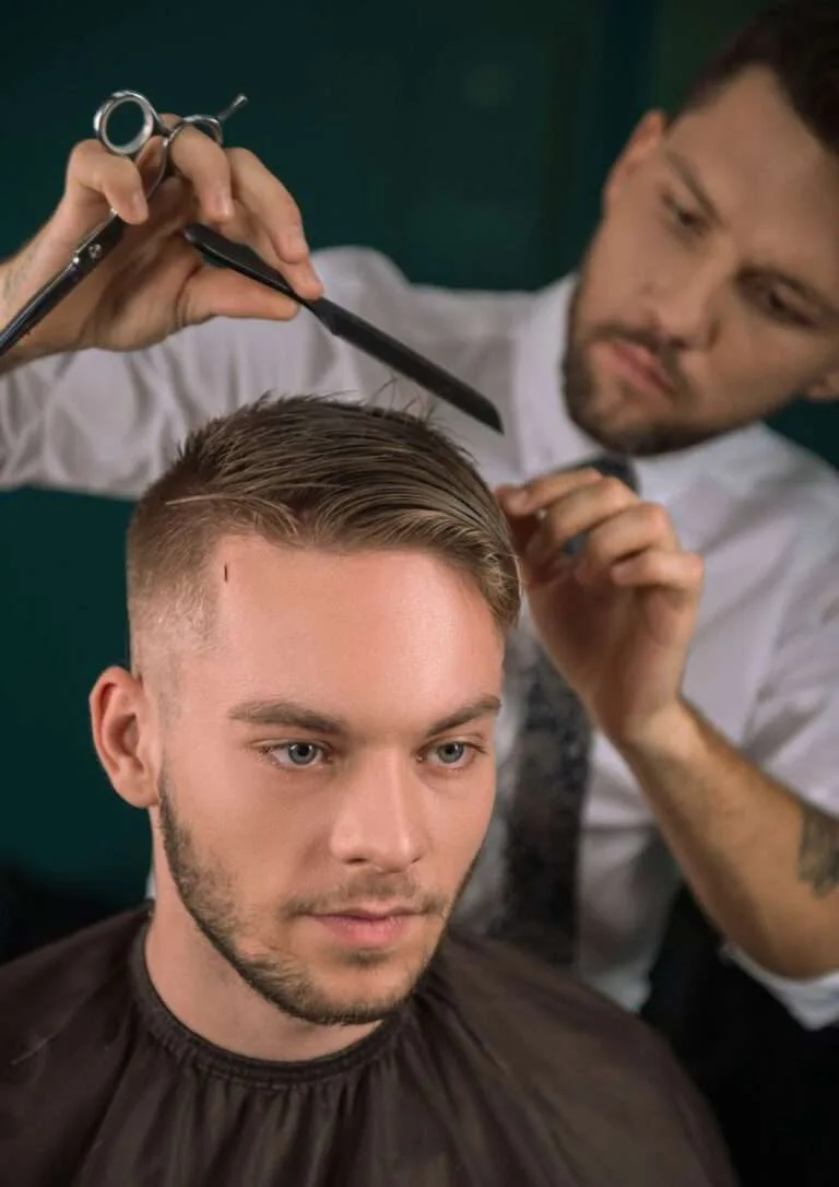 Barbero cortando el pelo a un cliente
