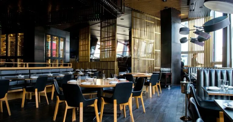 Comedor de restaurante con luz cálida y ventanal al fondo