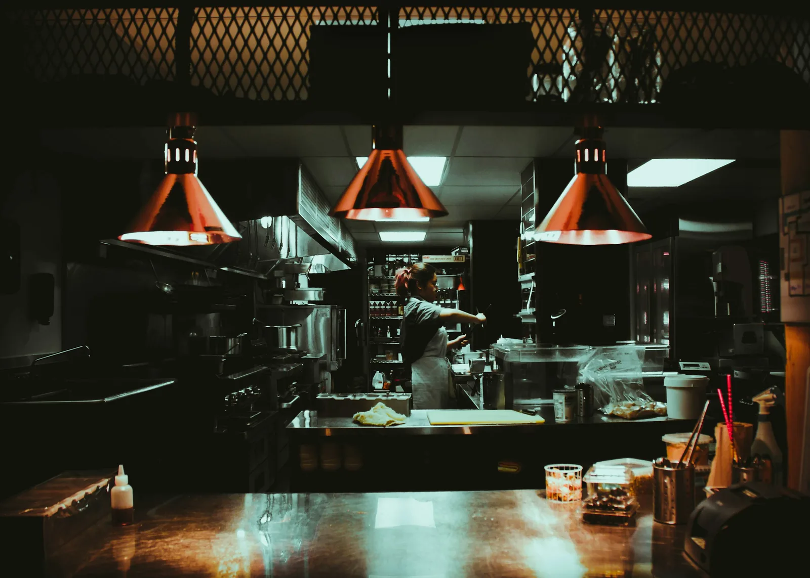 Pase de cocina de un restaurante iluminado con lámparas de calor de cobre