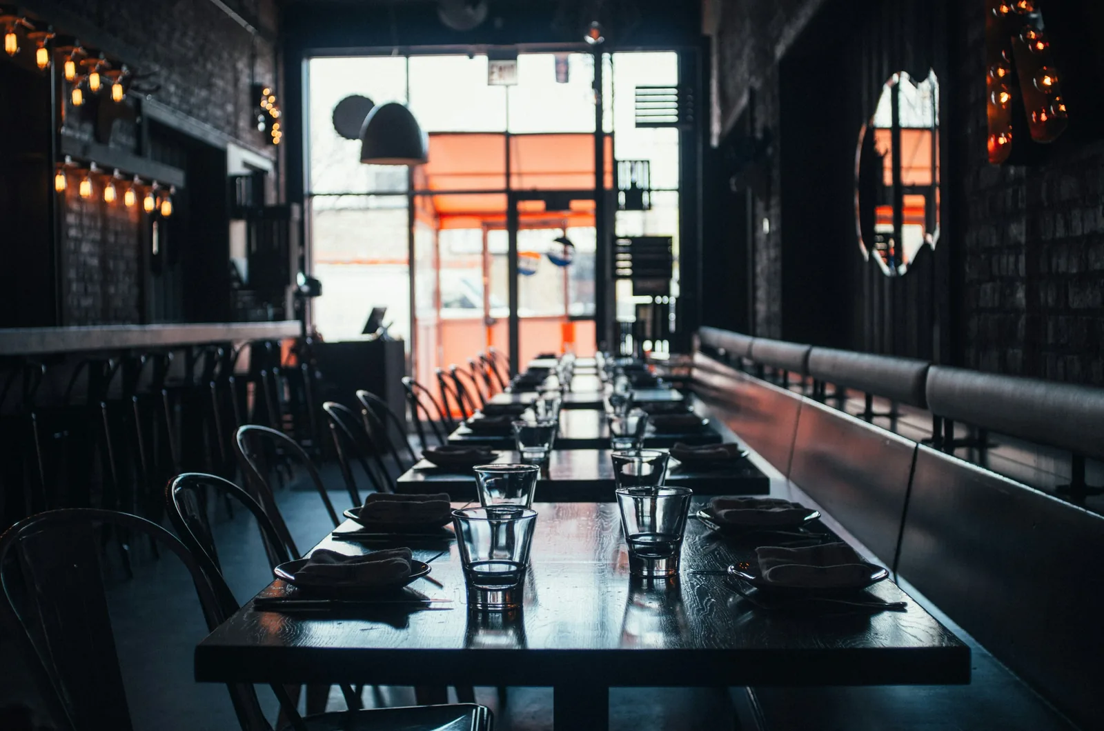Sala de restaurante vacía con la luz del día entrando por el ventanal del fondo