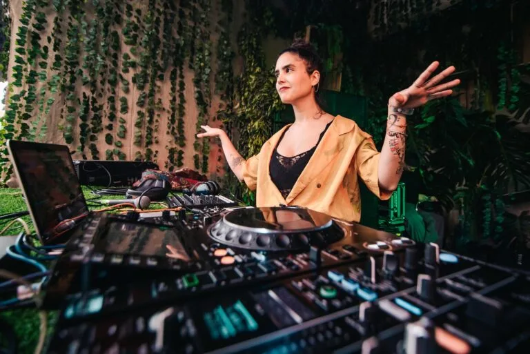 DJ actuando con las manos en alto en el escenario