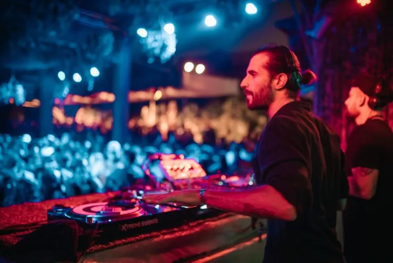 DJ actuando ante el público con luces azules