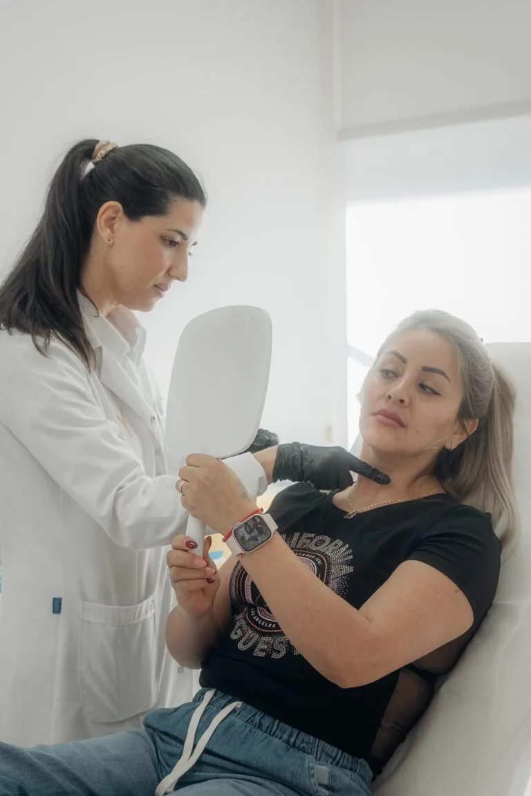 Doctora mostrando el resultado a la paciente en el espejo